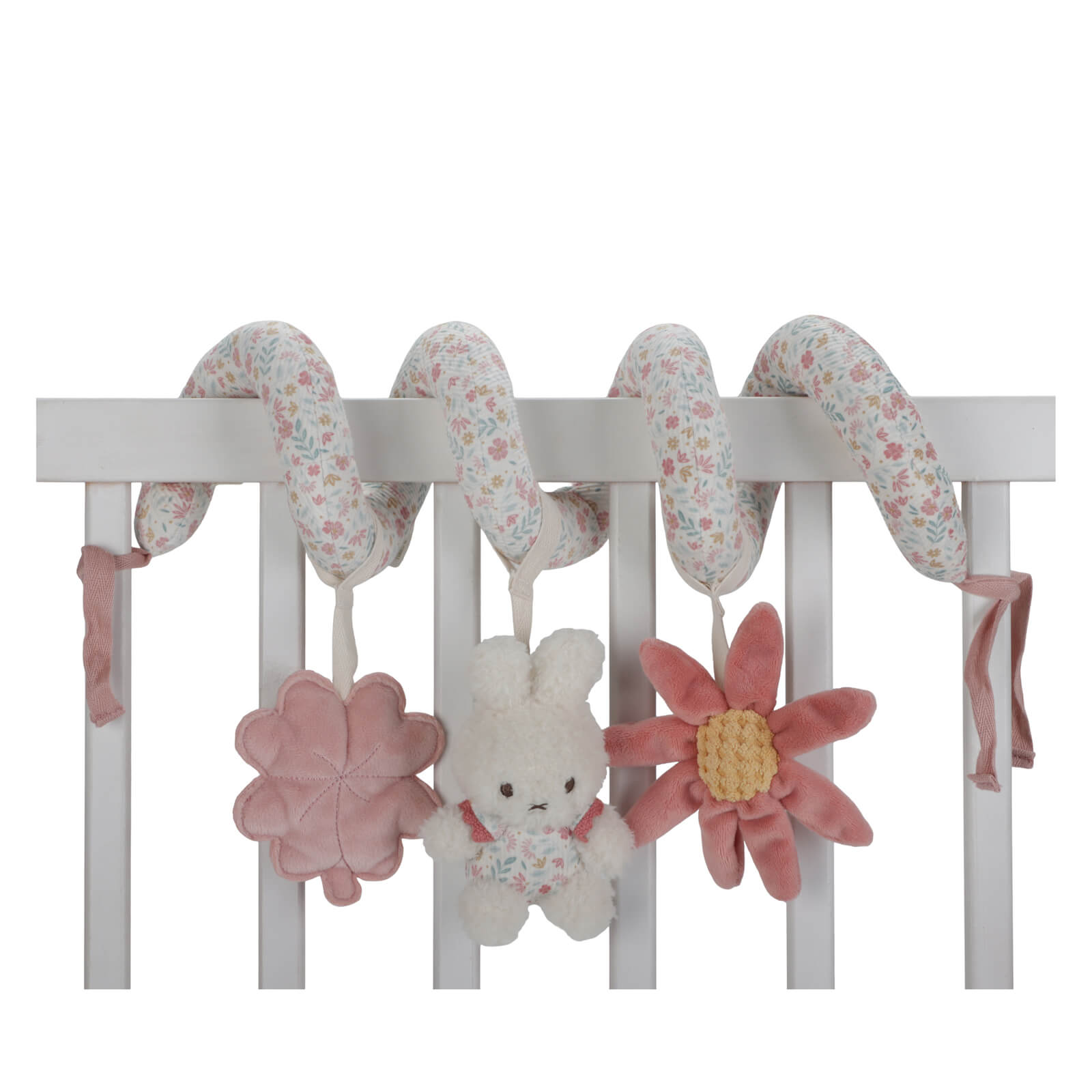 A baby activity spiral toy with floral patterns, hanging from a white crib. It features plush toys including a rabbit and a flower, along with a four-leaf clover.