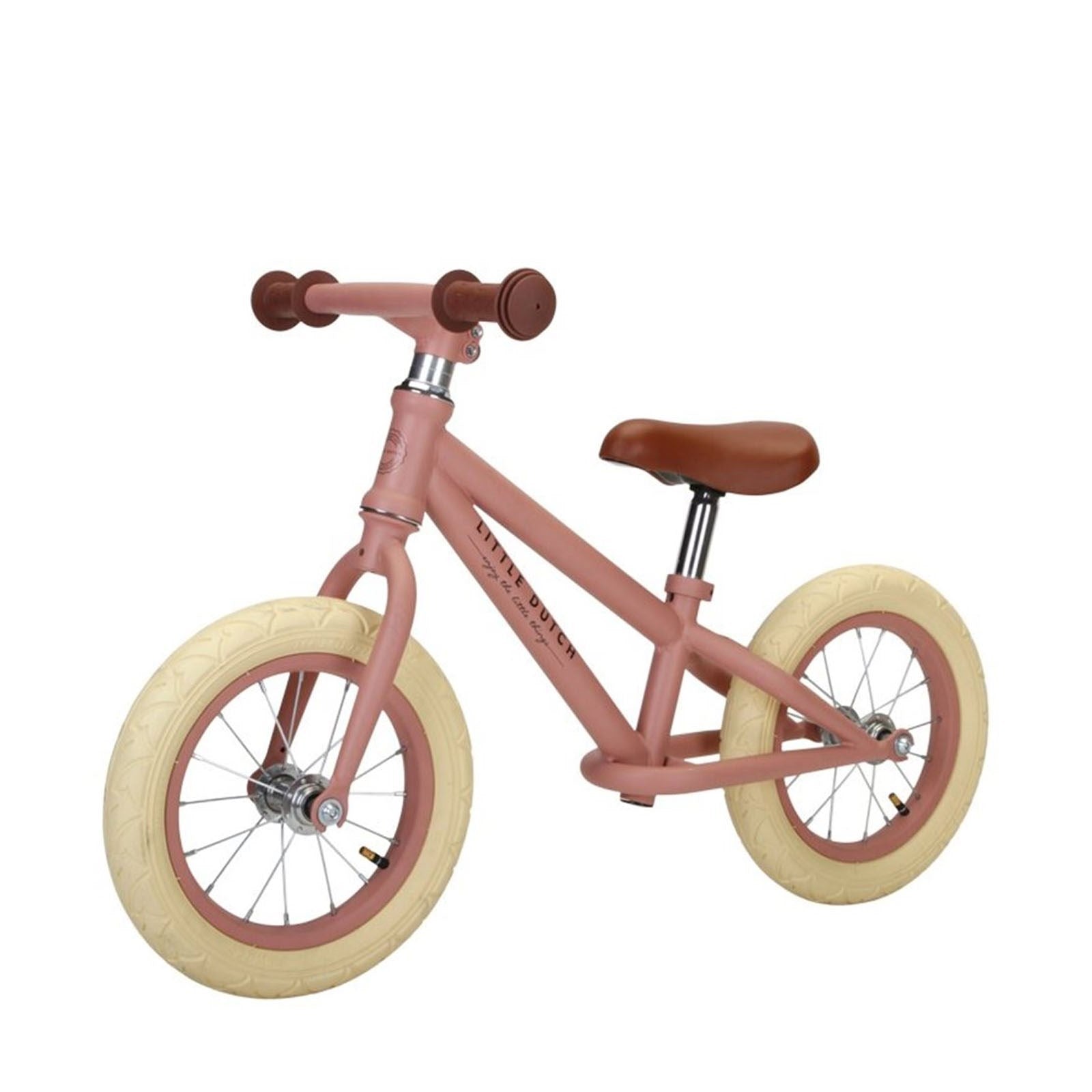 A matte pink 12-inch balance bike with rubber tires and a brown saddle and handle grips.
